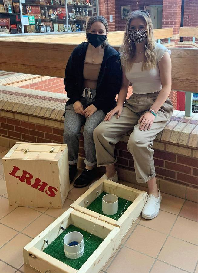 <p>CONTRIBUTED PHOTO</p><p>Grace Smith and Raya Stewart show off one of the auction items up for grabs through the LRHS Scholarship Auction. The washer toss game is one of four available made by the students in the LRHS Tech Ed. class.</p>